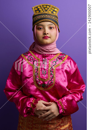 Young Indonesian Asian Woman in Pink Traditional Dress and Hijab Wearing Ornate Gold Headpiece Portrait 142900007