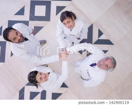 Middle Eastern medical team of doctors joining hands in hospital showing teamwork and unity Middle Eastern medical team of doctors joining hands in hospital showing teamwork and unity 142900119