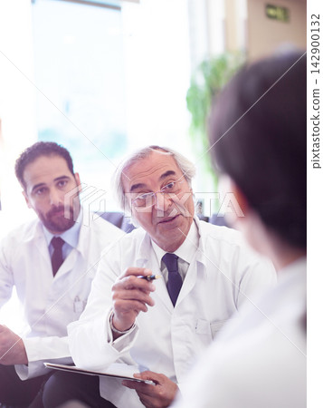 Middle Eastern doctors consulting with a patient in a hospital clinic during a team discussion Middle Eastern doctors consulting with a patient in a hospital clinic during a team discussion 142900132