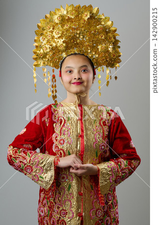 Traditional Headdress And Ornate Red Gold Costume Portrait Of A Young Indonesian Asian Girl For Festival Or Ceremony Traditional Headdress And Ornate Red Gold Costume Portrait Of A Young Indonesian Asian Girl For Festival Or Ceremony 142900215