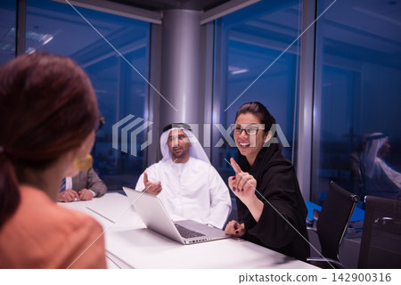 Middle Eastern business team in a modern office meeting with female leader presenting ideas Middle Eastern business team in a modern office meeting with female leader presenting ideas 142900316