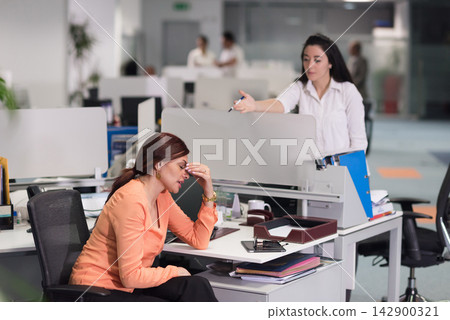 Middle Eastern colleagues in a modern office as a stressed employee receives feedback from a coworker Middle Eastern colleagues in a modern office as a stressed employee receives feedback from a coworker 142900321