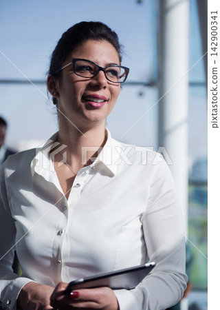 Middle Eastern businesswoman smiling in modern open space startup office during a casual business meeting Middle Eastern businesswoman smiling in modern open space startup office during a casual business meeting 142900341