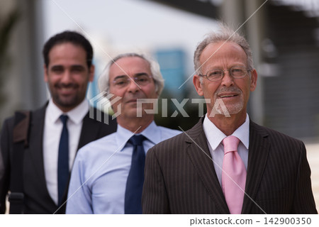 Middle Eastern businessmen standing together in modern office conveying teamwork, leadership and professionalism Middle Eastern businessmen standing together in modern office conveying teamwork, leadership and professionalism 142900350