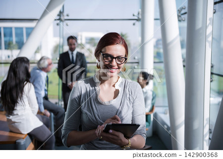 Middle Eastern business team in a modern open space office meeting with a smiling professional woman using a tablet Middle Eastern business team in a modern open space office meeting with a smiling professional woman using a tablet 142900368