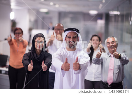 Middle Eastern business team in modern office giving thumbs up and celebrating success together Middle Eastern business team in modern office giving thumbs up and celebrating success together 142900374