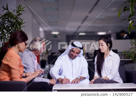 Middle Eastern business people signing contract in modern open-space office during friendly meeting Middle Eastern business people signing contract in modern open-space office during friendly meeting 142900527