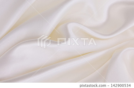 Smooth elegant white silk or satin luxury cloth texture as wedding background. Luxurious background design Smooth elegant white silk or satin luxury cloth texture as wedding background. Luxurious background design 142900534