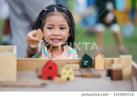 preschool child girl playing with wooden toy block at outdoor preschool child girl playing with wooden toy block at outdoor 142900558