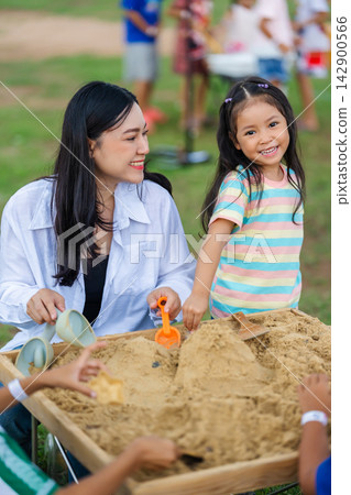 preschool child girl and mother playing with sand in sandbox outdoor preschool child girl and mother playing with sand in sandbox outdoor 142900566