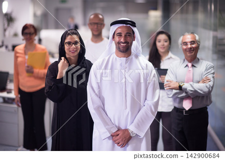 Middle Eastern business team in modern open office smiling leader and diverse colleagues during meeting Middle Eastern business team in modern open office smiling leader and diverse colleagues during meeting 142900684