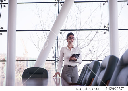 Middle Eastern businesswoman leading a meeting in a modern corporate boardroom with tablet in hand Middle Eastern businesswoman leading a meeting in a modern corporate boardroom with tablet in hand 142900871
