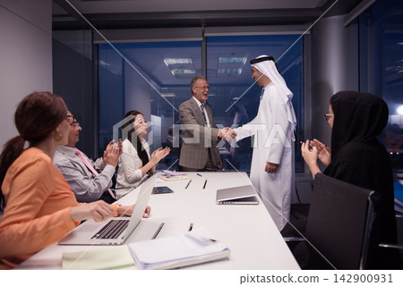 Middle Eastern and international business leaders shake hands in a modern office during a successful meeting Middle Eastern and international business leaders shake hands in a modern office during a successful meeting 142900931
