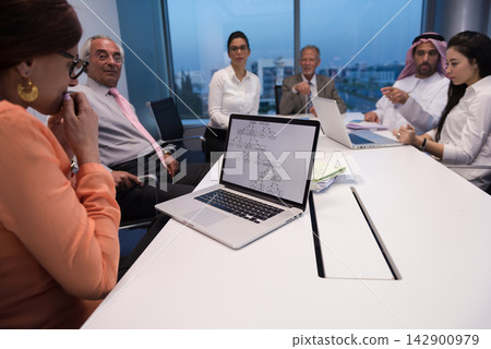 Middle Eastern and Arab business people in a modern office meeting around laptops discussing strategy and collaboration Middle Eastern and Arab business people in a modern office meeting around laptops discussing strategy and collaboration 142900979