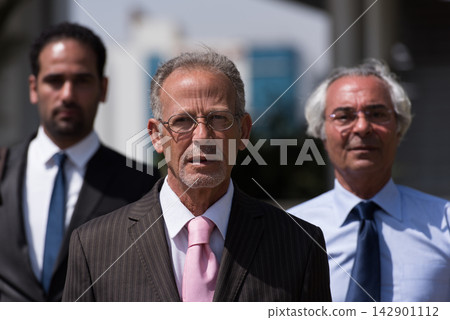 Middle Eastern business leaders standing confidently outside a modern corporate or startup office during a meeting Middle Eastern business leaders standing confidently outside a modern corporate or startup office during a meeting 142901112
