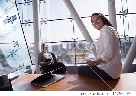 Middle Eastern businesswomen having a casual meeting in a modern open-plan startup office with city view Middle Eastern businesswomen having a casual meeting in a modern open-plan startup office with city view 142901143