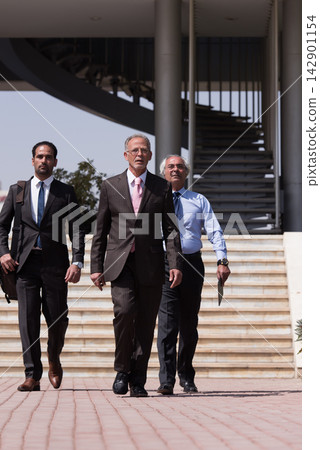 Middle Eastern business executives walking confidently outside a modern corporate startup office building Middle Eastern business executives walking confidently outside a modern corporate startup office building 142901154