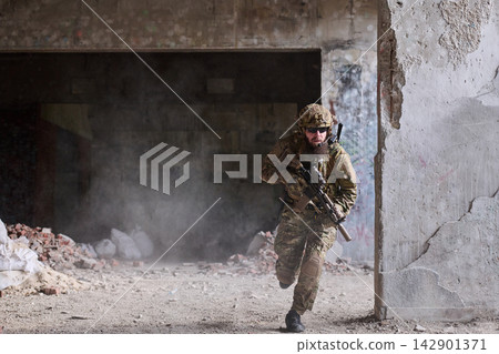 Soldier In Tactical Gear Running Through Abandoned Urban Building During Urban Combat Training Exercise Soldier In Tactical Gear Running Through Abandoned Urban Building During Urban Combat Training Exercise 142901371