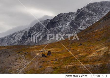 Harsh arctic mountain climate with first snow dusting dark peaks in late autumn Harsh arctic mountain climate with first snow dusting dark peaks in late autumn 142901391