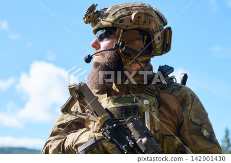 Bearded Special Forces Soldier in Tactical Gear With Helmet, Rifle and Radio Communication Outdoors Bearded Special Forces Soldier in Tactical Gear With Helmet, Rifle and Radio Communication Outdoors 142901430