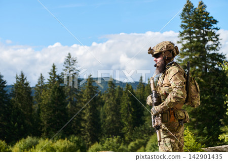 Soldier in Tactical Gear Standing in Forested Mountain Landscape During Training or Patrol Soldier in Tactical Gear Standing in Forested Mountain Landscape During Training or Patrol 142901435