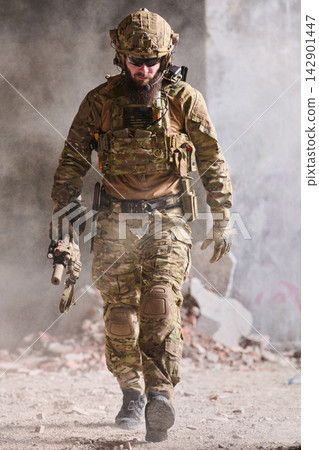 Tactical Soldier In Camouflage Gear Walking Through Dusty Urban Combat Ruins With Rifle Tactical Soldier In Camouflage Gear Walking Through Dusty Urban Combat Ruins With Rifle 142901447