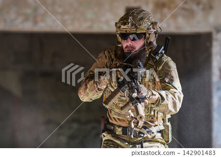 Armed Tactical Soldier In Camouflage Gear Aiming Rifle During Urban Military Training Operation 142901483