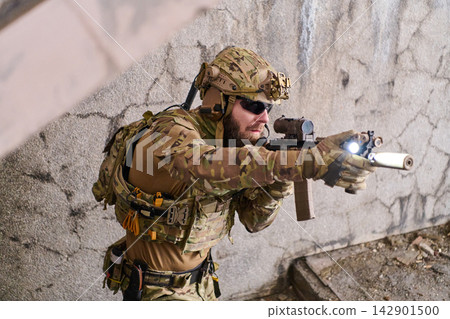 Tactical Soldier In Camouflage Aiming Rifle With Mounted Light During Urban Special Forces Operation Tactical Soldier In Camouflage Aiming Rifle With Mounted Light During Urban Special Forces Operation 142901500