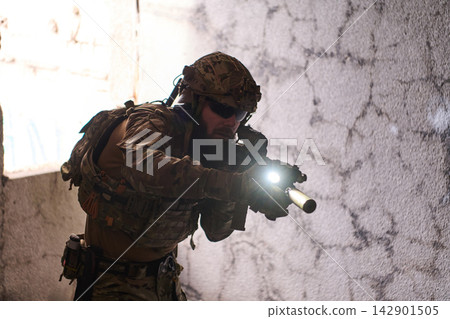 Tactical Soldier With Rifle and Flashlight Conducting Urban Close Quarters Battle Training Indoors Tactical Soldier With Rifle and Flashlight Conducting Urban Close Quarters Battle Training Indoors 142901505