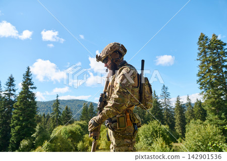 Military Soldier In Tactical Gear Standing In Forested Mountains During Daytime Patrol Military Soldier In Tactical Gear Standing In Forested Mountains During Daytime Patrol 142901536