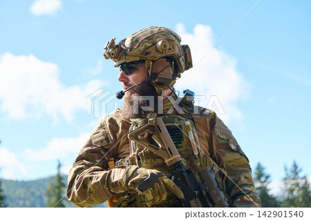 Bearded Soldier in Tactical Gear With Helmet and Rifle During Outdoor Military Operation Bearded Soldier in Tactical Gear With Helmet and Rifle During Outdoor Military Operation 142901540