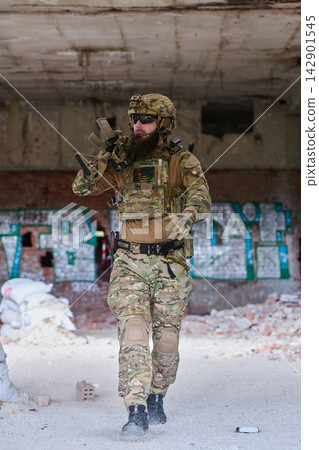 Tactical Soldier In Camouflage Gear Moving Through Abandoned Urban Building During Training Exercise Tactical Soldier In Camouflage Gear Moving Through Abandoned Urban Building During Training Exercise 142901545