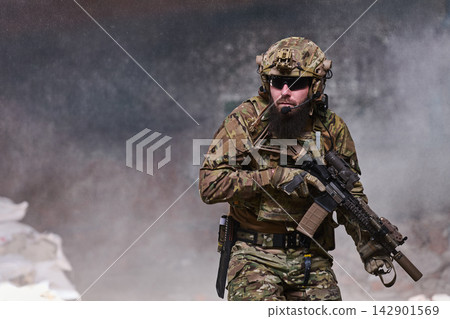 Bearded Soldier In Tactical Gear Holding Rifle During Urban Military Operation With Camouflage Uniform Bearded Soldier In Tactical Gear Holding Rifle During Urban Military Operation With Camouflage Uniform 142901569