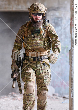 Armed Tactical Soldier in Multicam Gear Walking Through Urban Ruins With Helmet and Rifle Armed Tactical Soldier in Multicam Gear Walking Through Urban Ruins With Helmet and Rifle 142901571