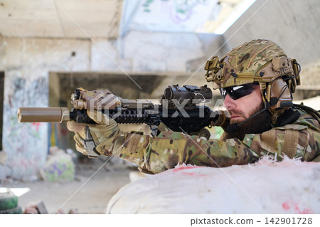 Soldier in Camouflage Gear Aiming Assault Rifle During Urban Training in Abandoned Building Soldier in Camouflage Gear Aiming Assault Rifle During Urban Training in Abandoned Building 142901728