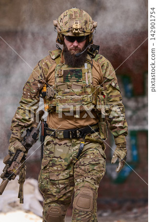 Armed Tactical Soldier in Camouflage Gear and Helmet Holding Rifle During Urban Military Operation Armed Tactical Soldier in Camouflage Gear and Helmet Holding Rifle During Urban Military Operation 142901754