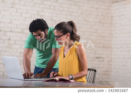 Young Middle Eastern business colleagues collaborating on a startup project in a creative coworking office space Young Middle Eastern business colleagues collaborating on a startup project in a creative coworking office space 142901887