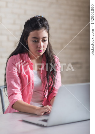 Young Middle Eastern woman working on laptop in creative coworking startup office open space Young Middle Eastern woman working on laptop in creative coworking startup office open space 142901890