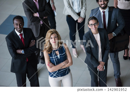 Confident diverse business team of professionals standing together in modern corporate office looking up Confident diverse business team of professionals standing together in modern corporate office looking up 142901952