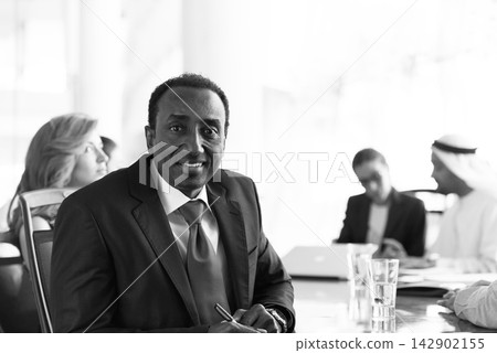 Middle Eastern business executive leading a modern corporate meeting in an open office boardroom Middle Eastern business executive leading a modern corporate meeting in an open office boardroom 142902155