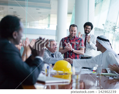 Multicultural Middle Eastern business team in a modern meeting celebrating successful agreement and collaboration 142902239