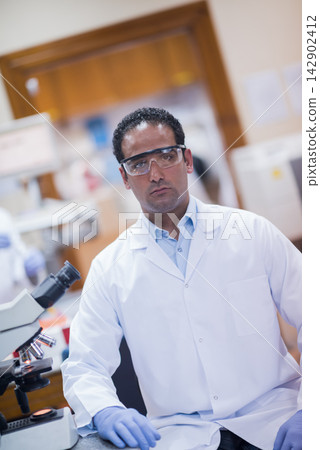 Middle Eastern lab scientist in white coat conducting blood testing in a clinical research laboratory Middle Eastern lab scientist in white coat conducting blood testing in a clinical research laboratory 142902412
