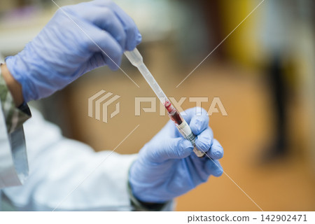 Young Middle Eastern doctors and medical technician handling blood sample in clinical testing laboratory with gloves Young Middle Eastern doctors and medical technician handling blood sample in clinical testing laboratory with gloves 142902471