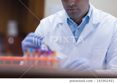 Young medical technician in lab coat preparing blood samples for testing in clinical laboratory Young medical technician in lab coat preparing blood samples for testing in clinical laboratory 142902481