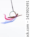 Young aerialist extending from hoop with pastel fabric 142902491