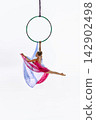 Teen gymnast posing below green aerial ring 142902498