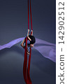 Teen girl folding into aerial silk pose 142902512