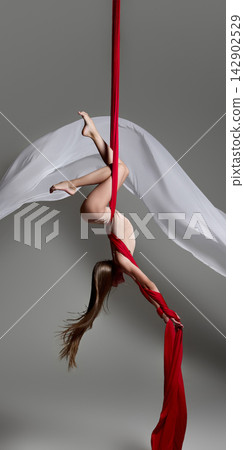 Young aerial gymnast arching upside down on silks Young aerial gymnast arching upside down on silks 142902529