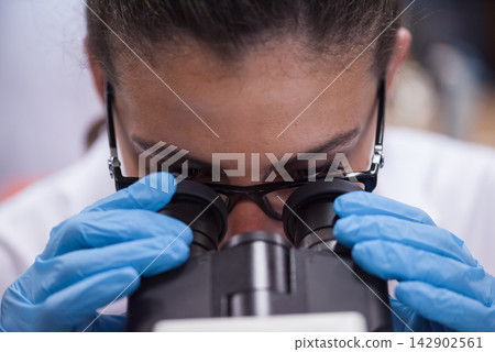 Middle Eastern medical technician and young doctor examining blood samples under a microscope in a lab Middle Eastern medical technician and young doctor examining blood samples under a microscope in a lab 142902561