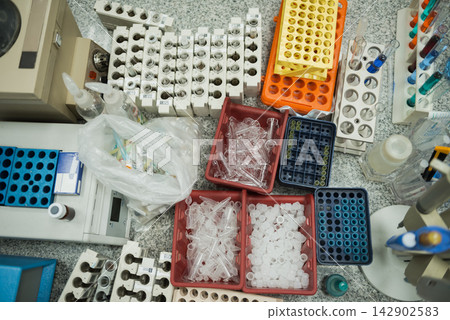 Overhead view of medical laboratory bench with blood testing tubes, racks and plastic vials Overhead view of medical laboratory bench with blood testing tubes, racks and plastic vials 142902583